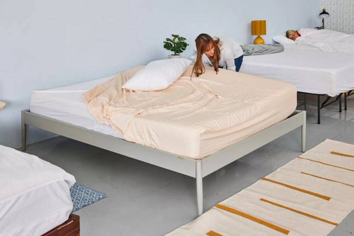 An uncovered pillow resting on the Tempur-Pedic 400 Thread Count Cool Luxury Sheet Set, partially laid on a mattress