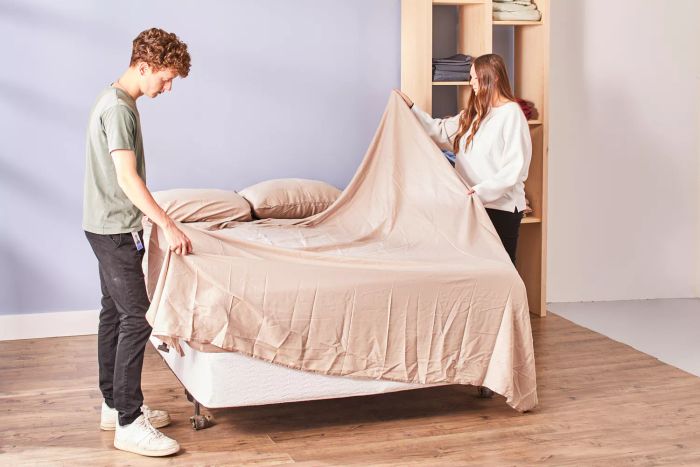 Two individuals making a bed with Linenwalas 100% Tencel Lyocell Bed Sheets