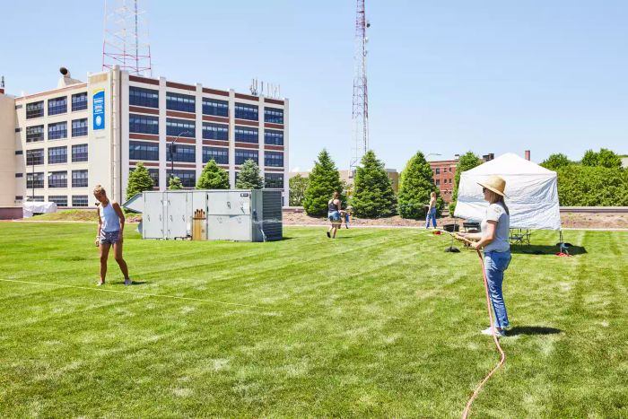 Person spraying water with the Relaxed Gardener Watering Wand across a grass lawn