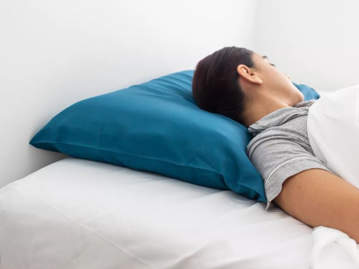 Person resting on their back on The Company Store Dual Memory Foam and Gel Fiber Pillow.