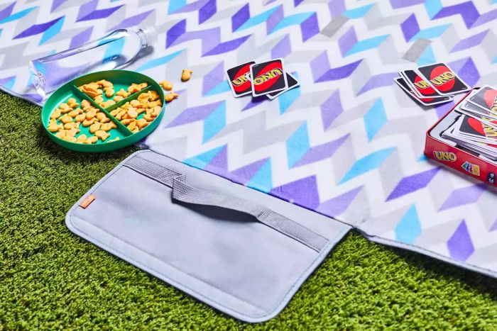 Yodo Outdoor Picnic Blanket showcased with goldfish snacks on a plate and UNO cards placed on top