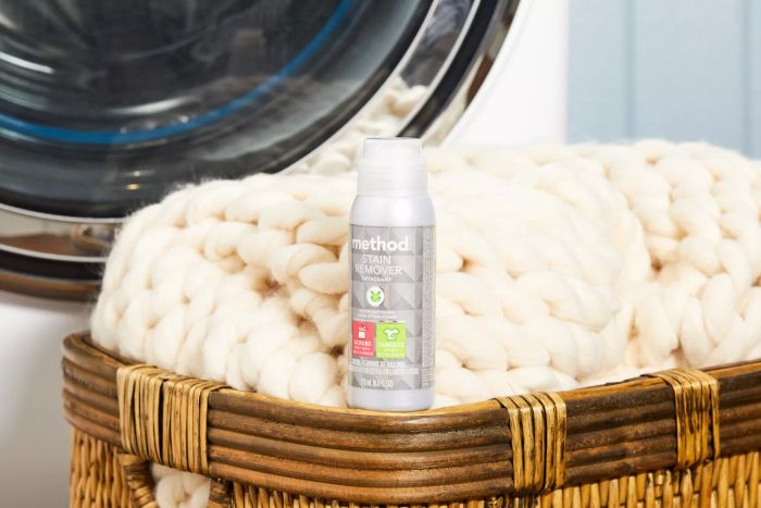 Method Stain Remover placed next to a laundry basket with a soft knit blanket