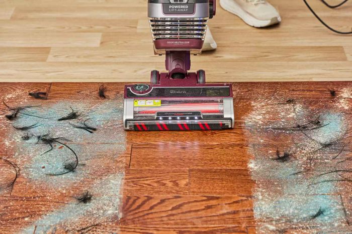The Shark Stratos Upright Vacuum is cleaning dirt from a wooden floor.