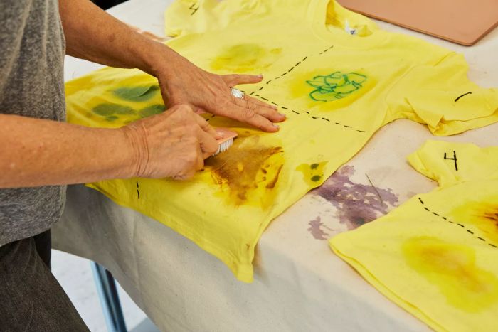 Person scrubbing a stain off a t-shirt with a brush