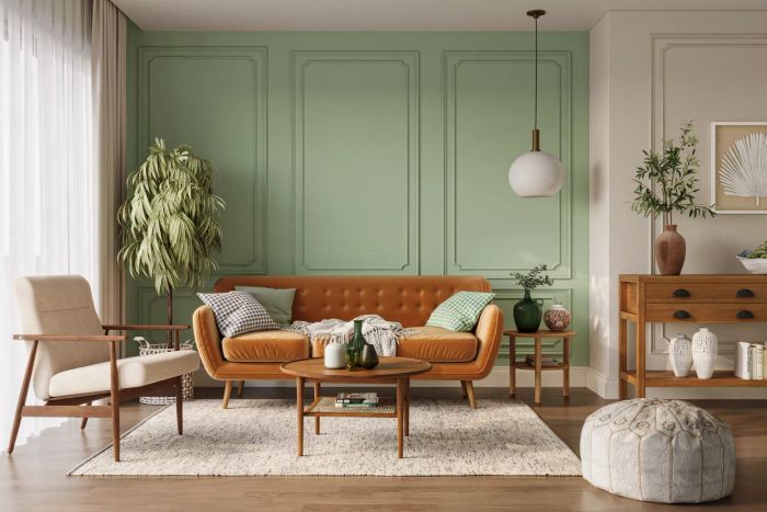 A cozy living room featuring an orange sofa, pastel green walls, and wooden furniture. Wall mockup included.