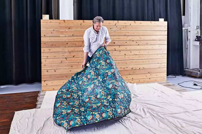 Person laying out the Roebury Outdoor Picnic Blanket on the floor