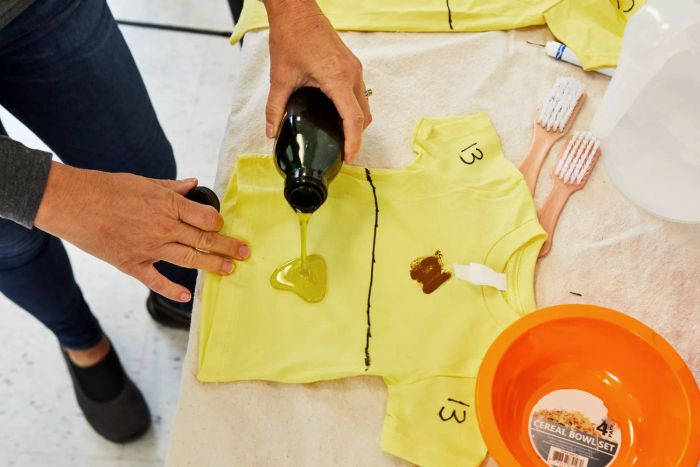Person applying oil to a T-shirt
