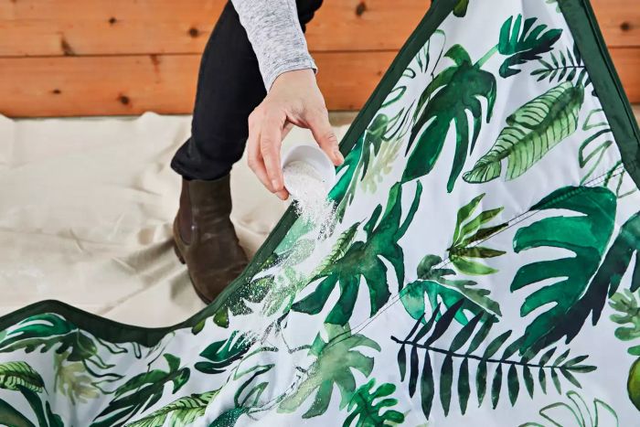 Person testing the Little Unicorn Indoor/Outdoor Blanket by spilling dust on it