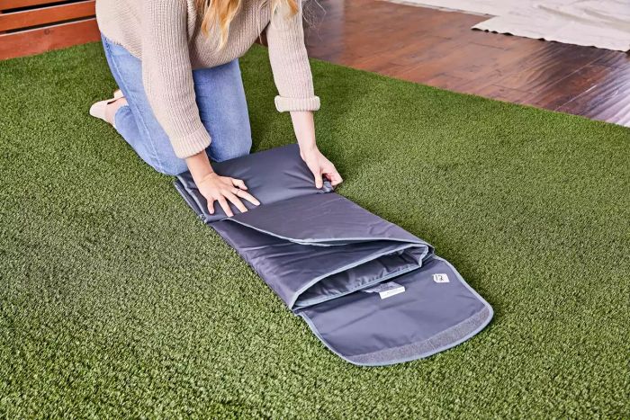 A woman folding an outdoor blanket