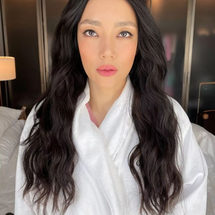 Long, thick, wavy hair styled with soft waves.
