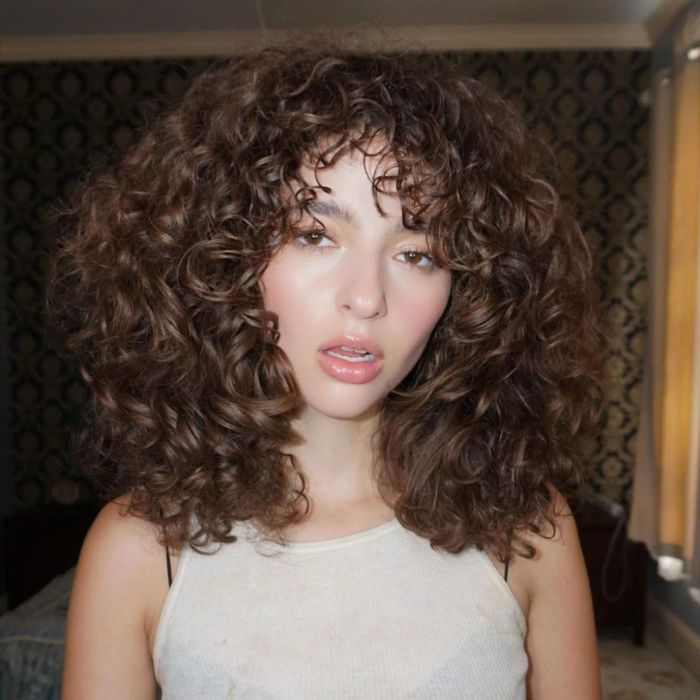 Shoulder-length, thick brown curly hair.