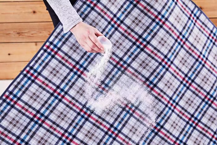 Person testing the Oniva Blanket Tote by spilling dust on it