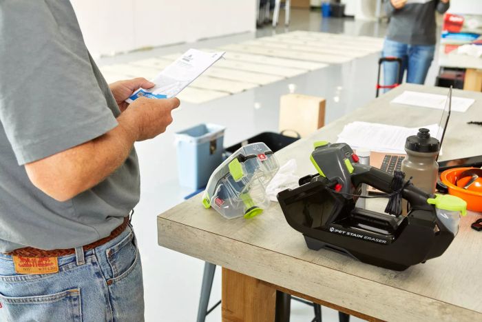 A person reading the instructions for the Bissell Pet Stain Eraser Plus