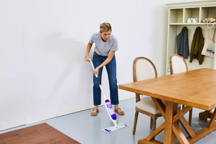 A person mopping a linoleum floor using the Swiffer PowerMop Multi-Surface Kit
