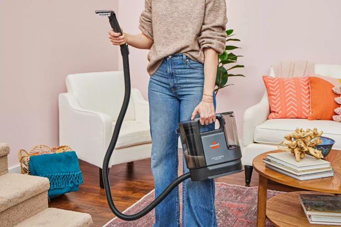 A person holding the Bissell Little Green Cordless Portable Carpet Cleaner 3682