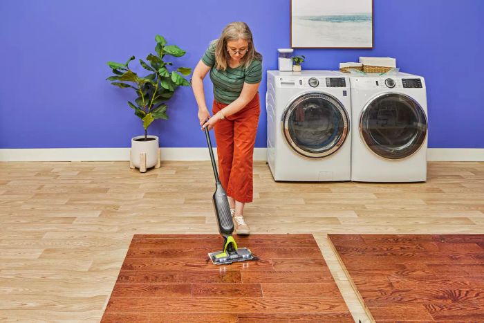 An individual uses the Shark VM252 Vacmop Pro Cordless Wet/Dry Stick Vacuum to clean a wooden surface