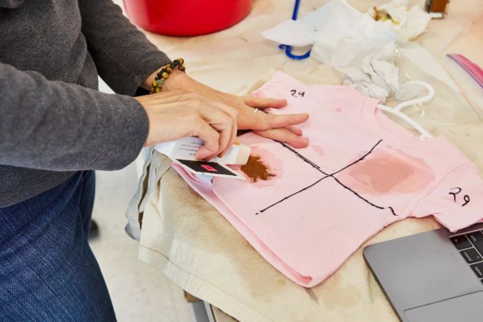 A person applying the Meliora Laundry Stain Removal Soap Stick on a stained T-shirt