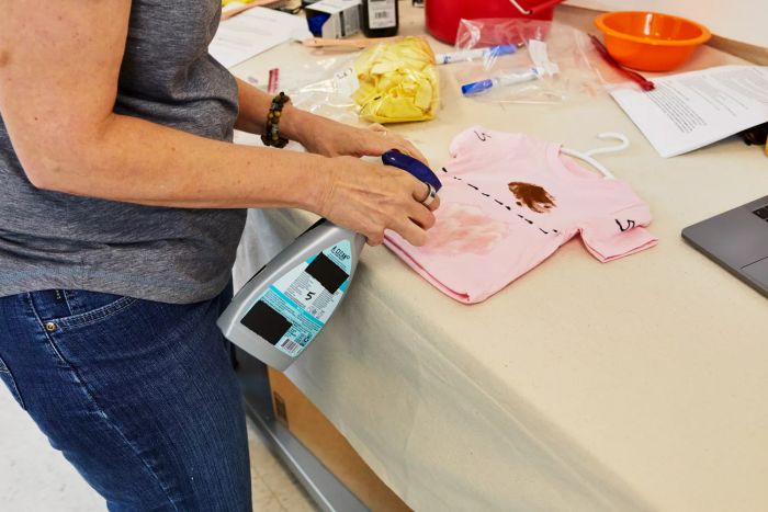 Individual applying Seventh Generation Laundry Stain Remover to a stain on a t-shirt