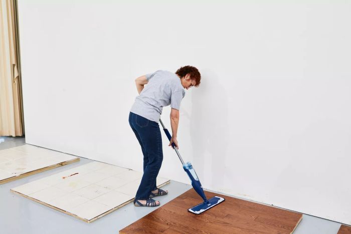 A person cleaning a wooden floor using the Bona Hardwood Floor Premium Spray Mop