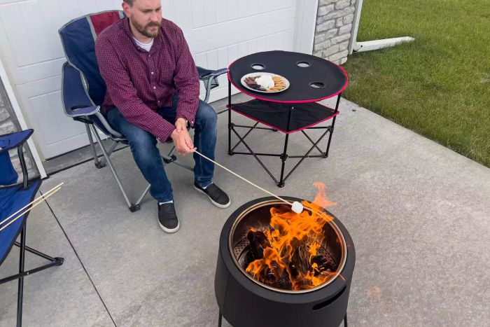 A person roasting a marshmallow over the Tiki Social Smokeless Fire Pit