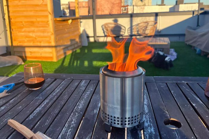 The Solo Stove Mesa Smokeless Fire Pit in action, burning on a patio table
