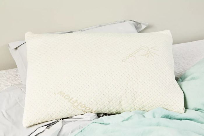 The Snuggle-Pedic Adjustable Shredded Memory Foam Pillow placed on a bed