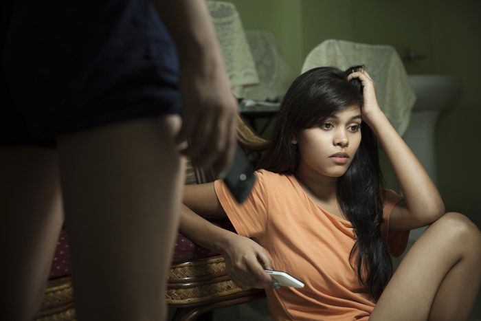 a person staring blankly ahead while someone attempts to talk to them