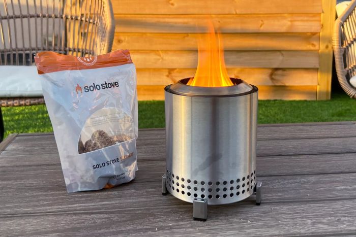 A flame burning inside the Solo Stove Mesa Smokeless Tabletop Firepit on a patio table