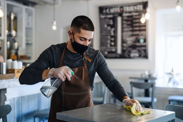 a person cleaning tables at a café