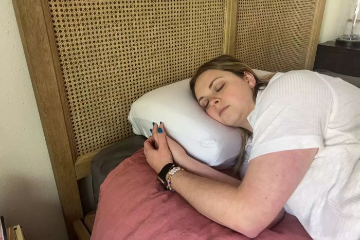 A person resting on the Purple DreamLayer Pillow