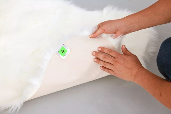 A person feeling the underside of the Ashler Faux Fur Rug