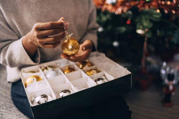 An unidentified woman holding a Christmas ornament, preparing to decorate for the holidays