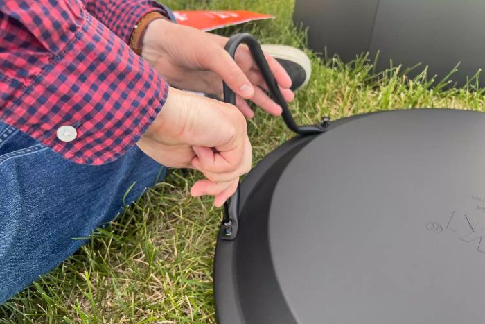A person assembling the Tiki Social Smokeless Fire Pit