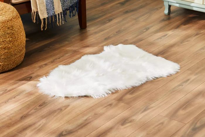 The Ashler Faux Fur Rug placed on a hardwood floor