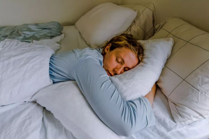 A person resting on the Coop The EdenCool+ Adjustable Pillow
