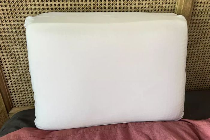 The Purple DreamLayer Pillow placed on a bed
