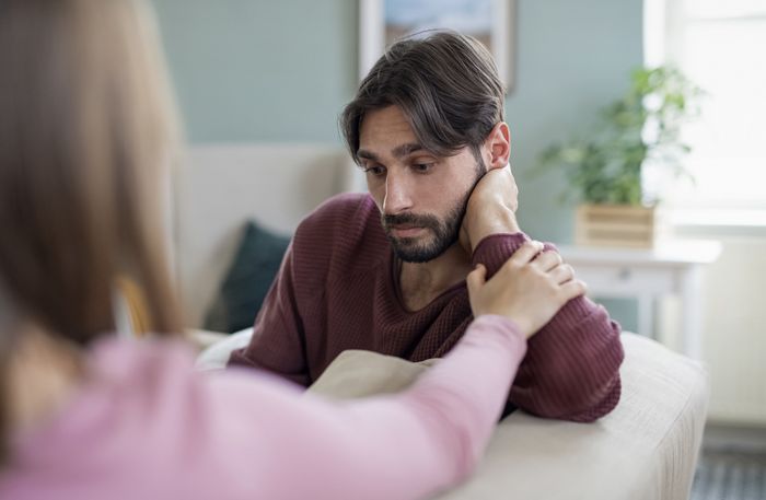 a close-up of a woman attempting to comfort a man