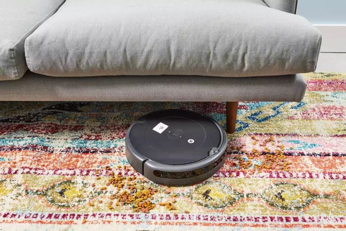 The iRobot Roomba 694 Robot Vacuum successfully cleaned a rug situated under a couch.