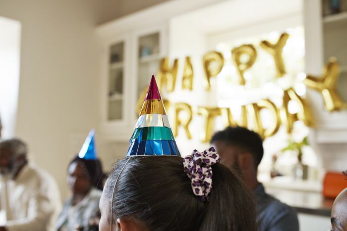 a birthday hat placed on someone's head