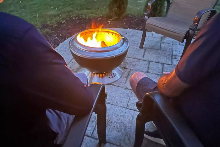 Two individuals seated near the Cuisinart COH-800 Cleanburn Smokeless 24 Inch Fire Pit