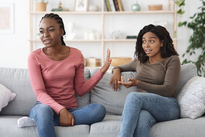 one person extending their hand to another while sitting beside them on a couch