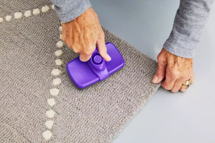 A person brushing the Rugs USA Dotted Diamond Trellis Nursery Area Rug