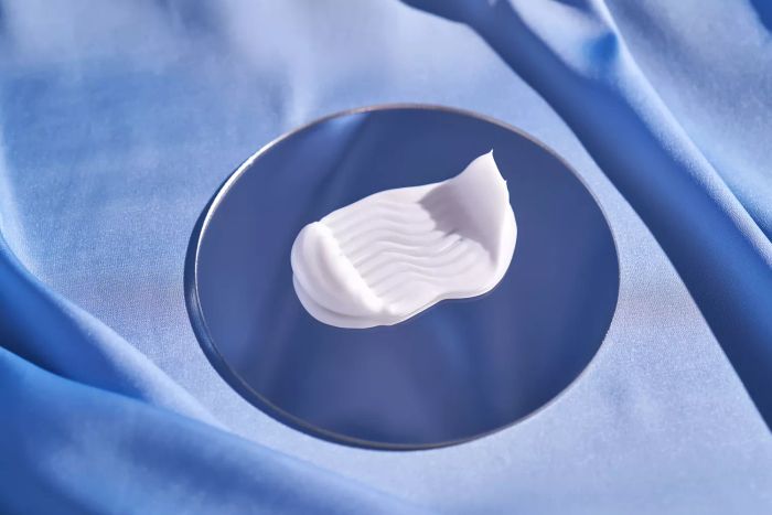 A streak of white cream set against a backdrop of blue silk.