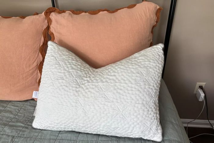 The Sleep Number ComfortFit Pillow displayed on a bed