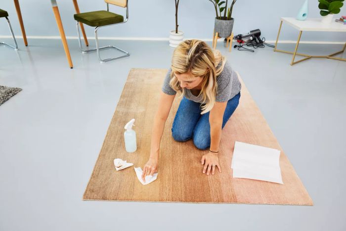 A person blotting the Revival Dawn Ombre Wool Rug