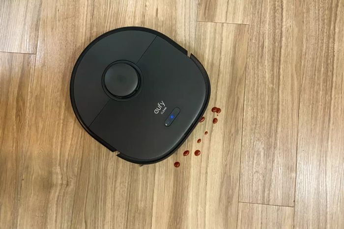 A top-down view shows the Eufy Clean X9 Pro Robotic Vacuum tackling a spill on a wooden floor.