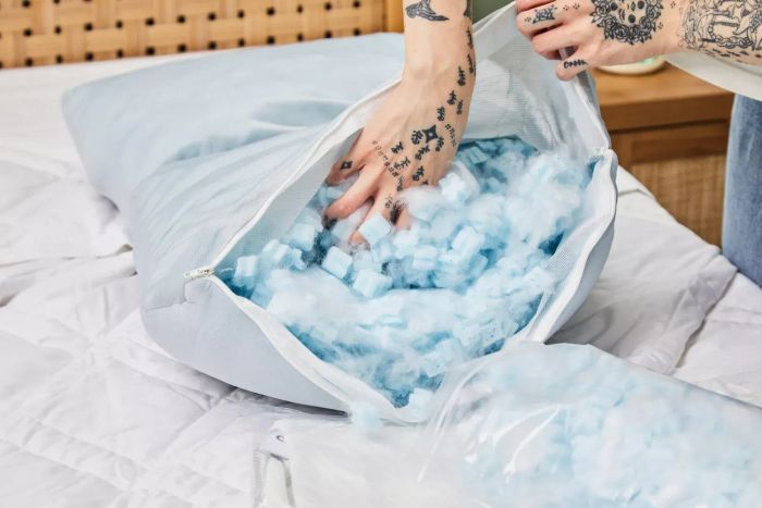 A person adding filling to the Coop The EdenCool+ Adjustable Pillow