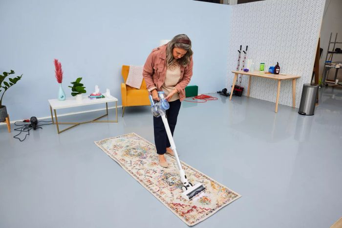 A person vacuuming the Safavieh Crystal Collection Rug