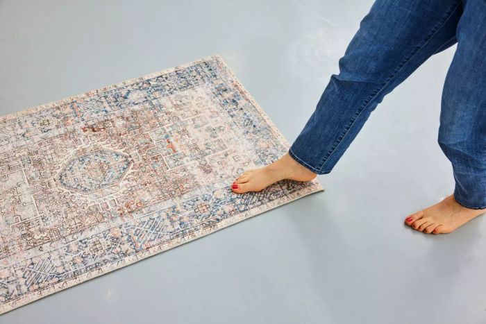 A person walking barefoot on the Chris Loves Julia x Loloi Jules Oriental Area Rug