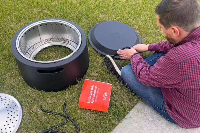 A person putting together the Tiki Social Smokeless Fire Pit